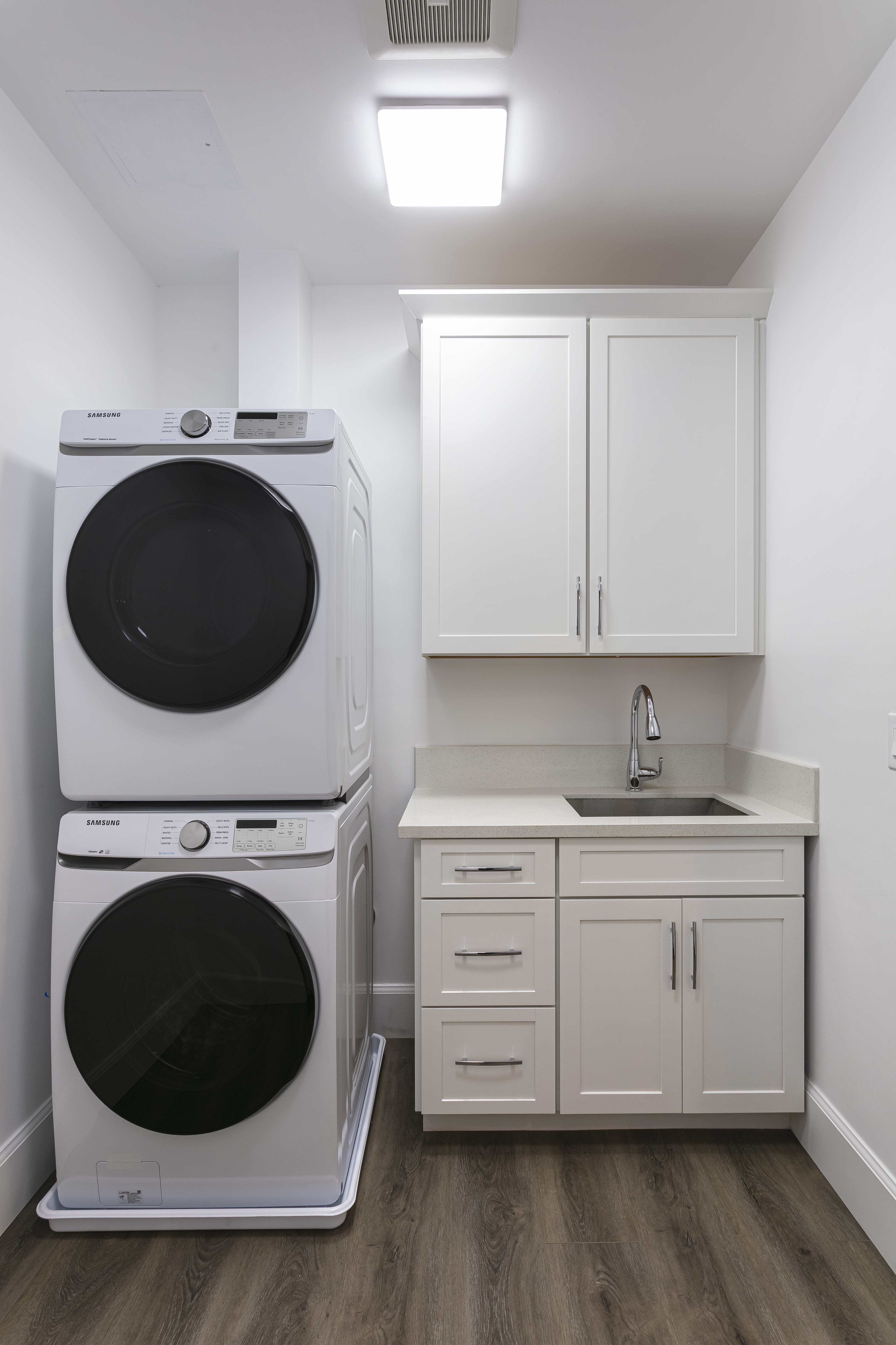 ADU in-unit laundry with stacked washer/dryer and custom cabinetry