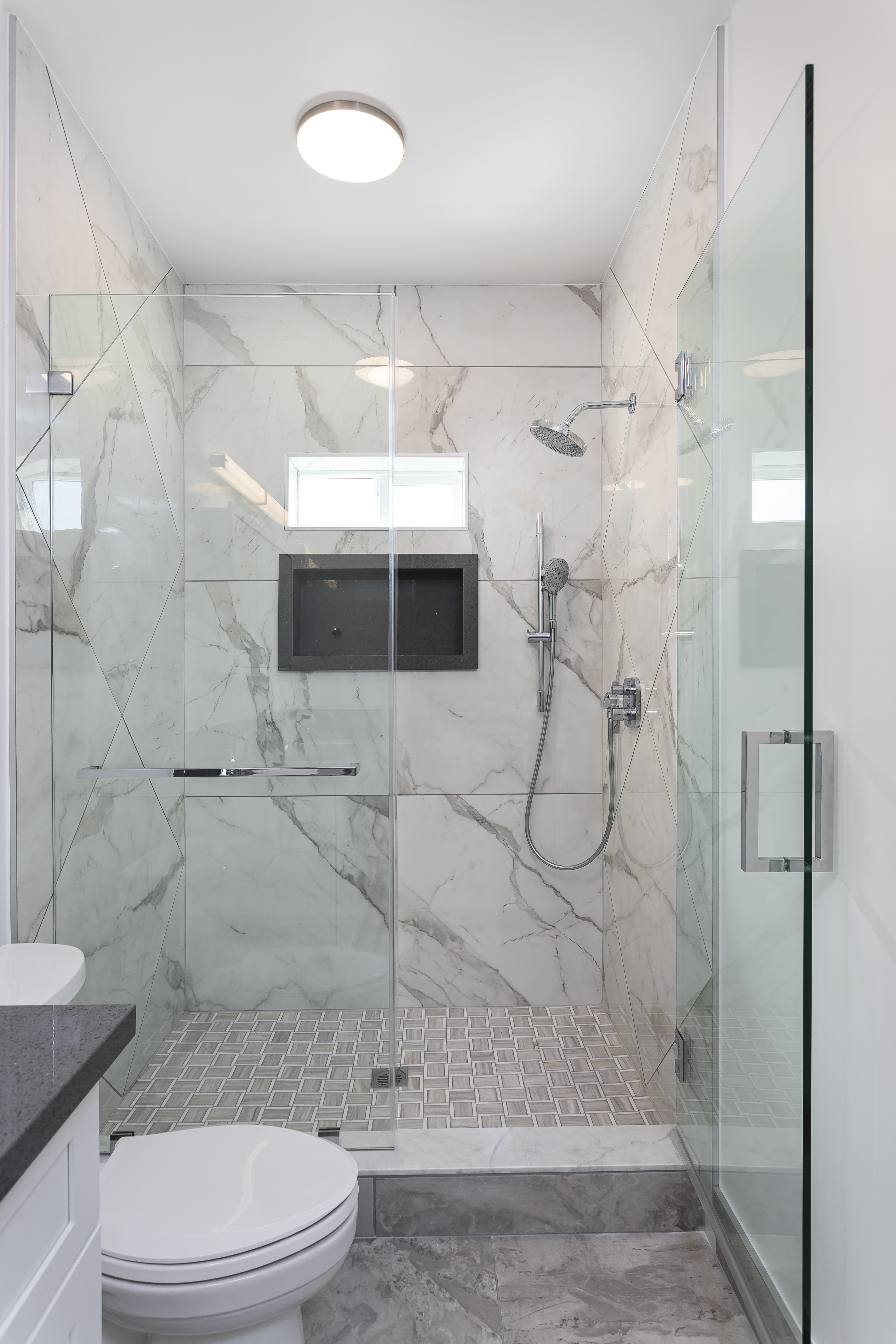 ADU marble spa shower — full enclosure with rain head and niche